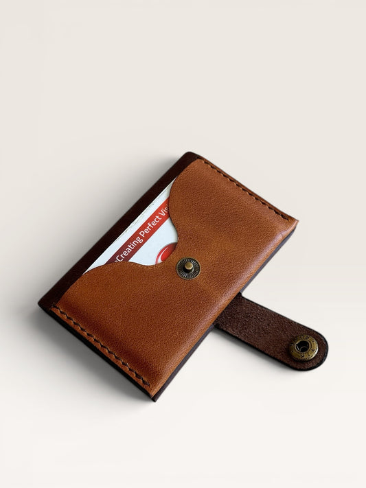Safir Leather minimalist tan genuine leather card holder with snap closure and dark brown trim.