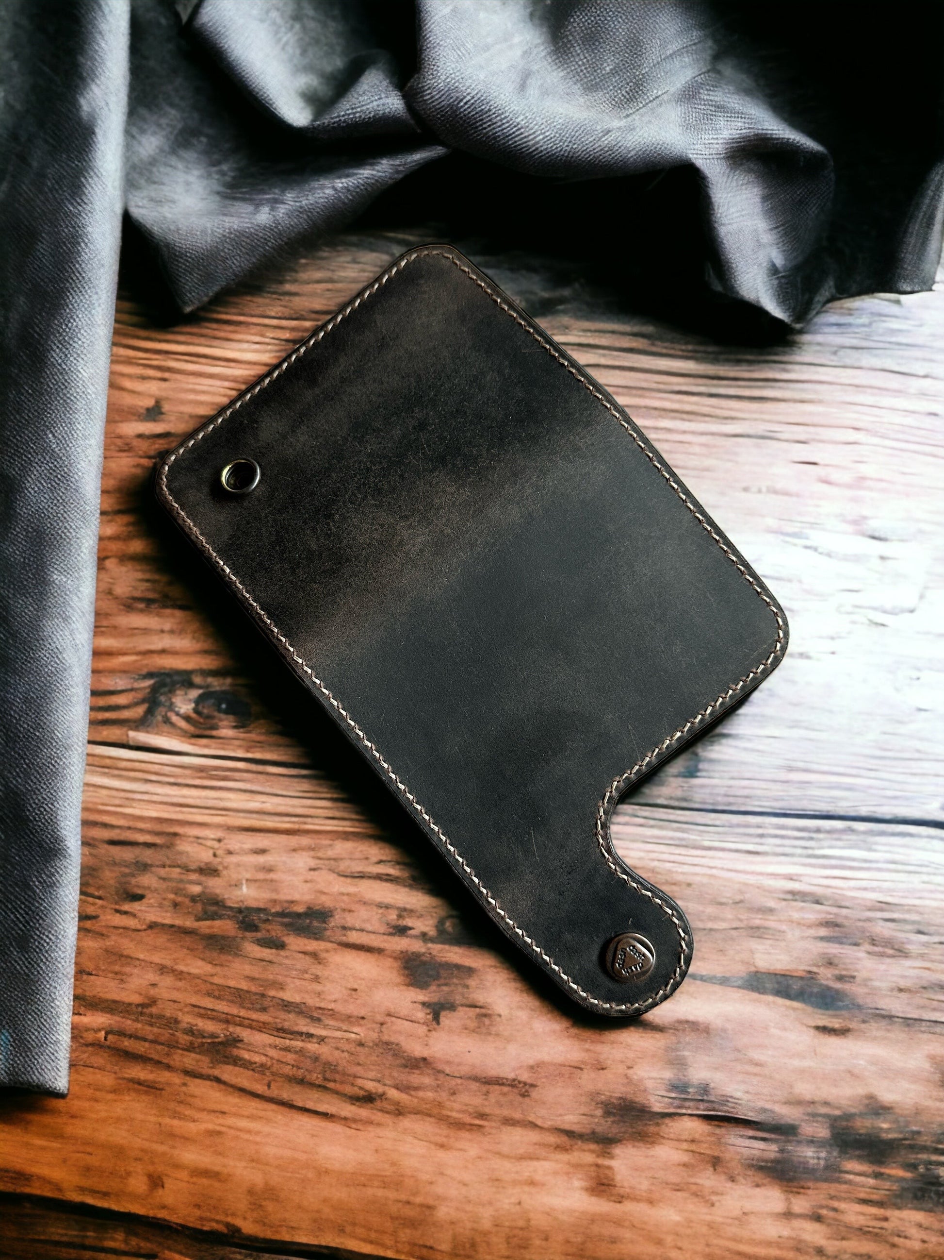 Safir Leather el yapımı, vintage görünümlü, koyu renkli hakiki deri cüzdan, ahşap zemin üzerinde.
