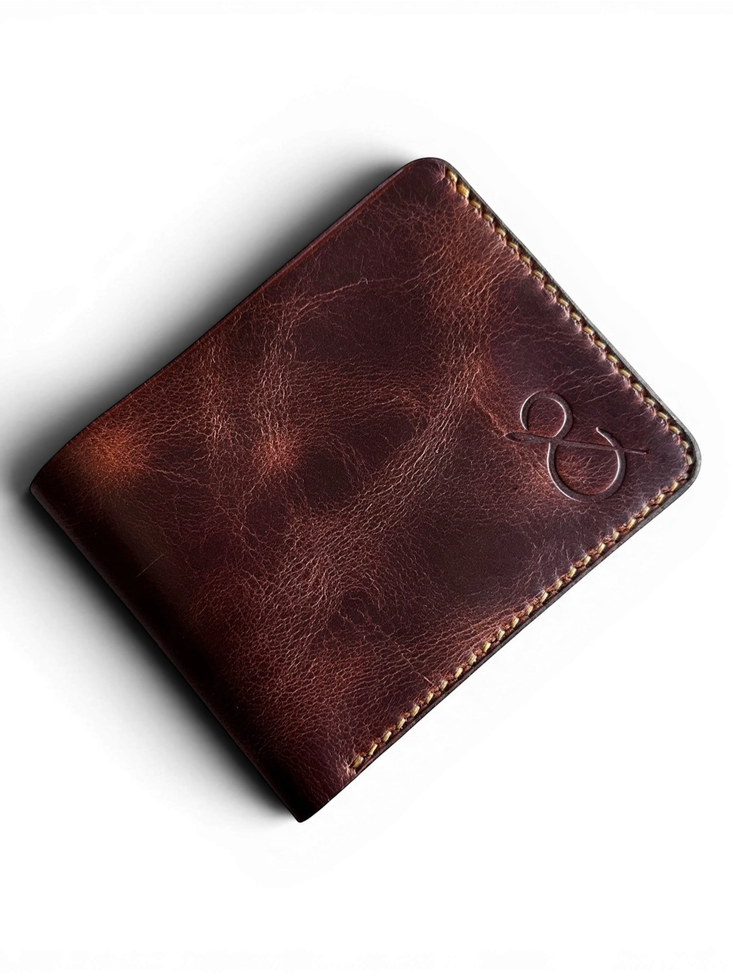 Safir Leather el yapımı, koyu kahverengi hakiki deri cüzdan, belirgin dikiş detayları ve minimalist logo tasarımı.