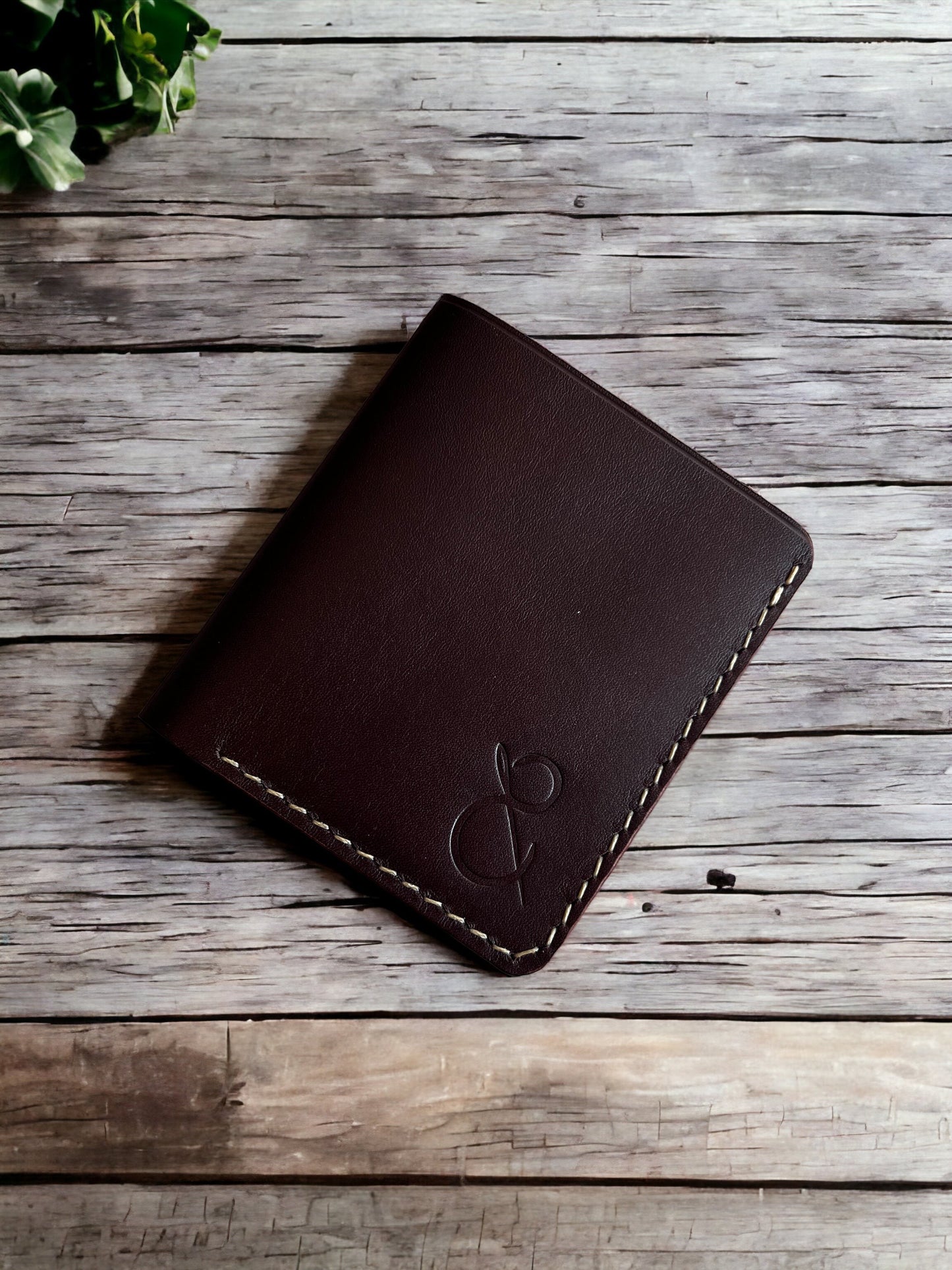 Safir Leather el yapımı kahverengi bufalo derisi cüzdan, dikişli kenarları ve kabartmalı logosu ile.