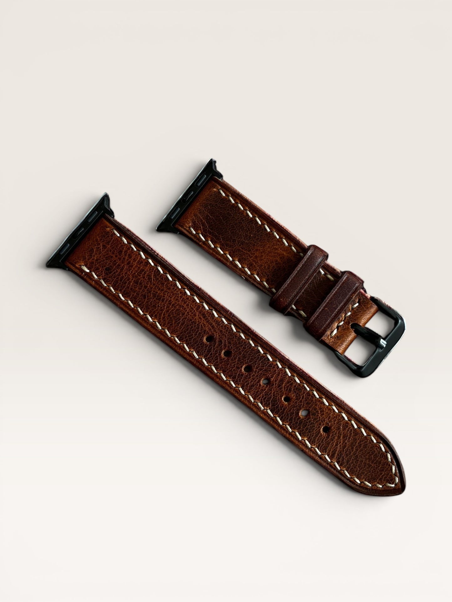 Safir Leather kahverengi çift kat deri Apple Watch kordonu, beyaz dikişli, paslanmaz çelik toka ve adaptörlü.