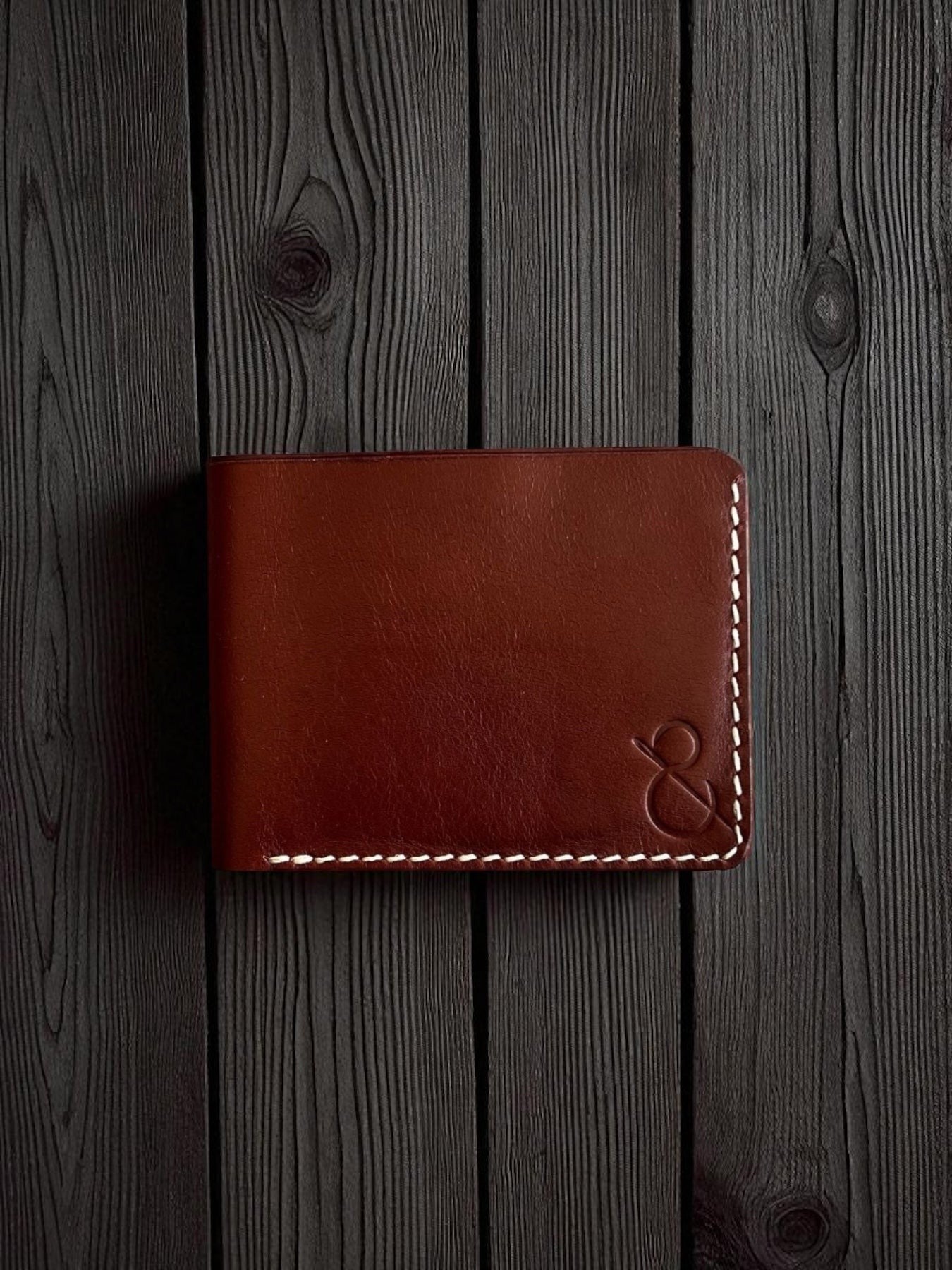 Safir Leather kızıl vajetal deri cüzdan, el yapımı mumlu dikişli minimal tasarım, koyu ahşap zemin üzerinde