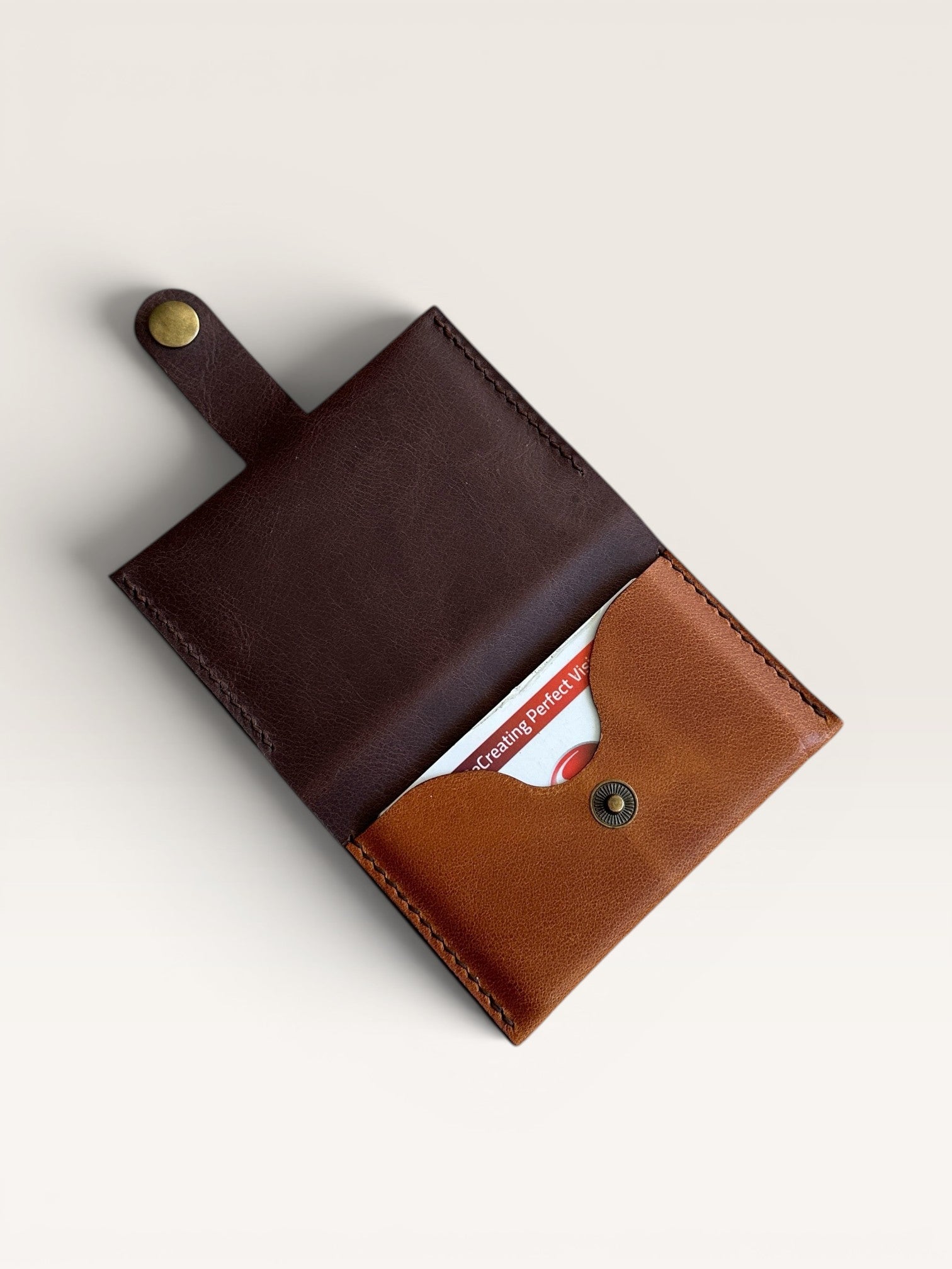 Safir Leather minimalist card holder in dark brown and tan genuine leather with brass snap closure.