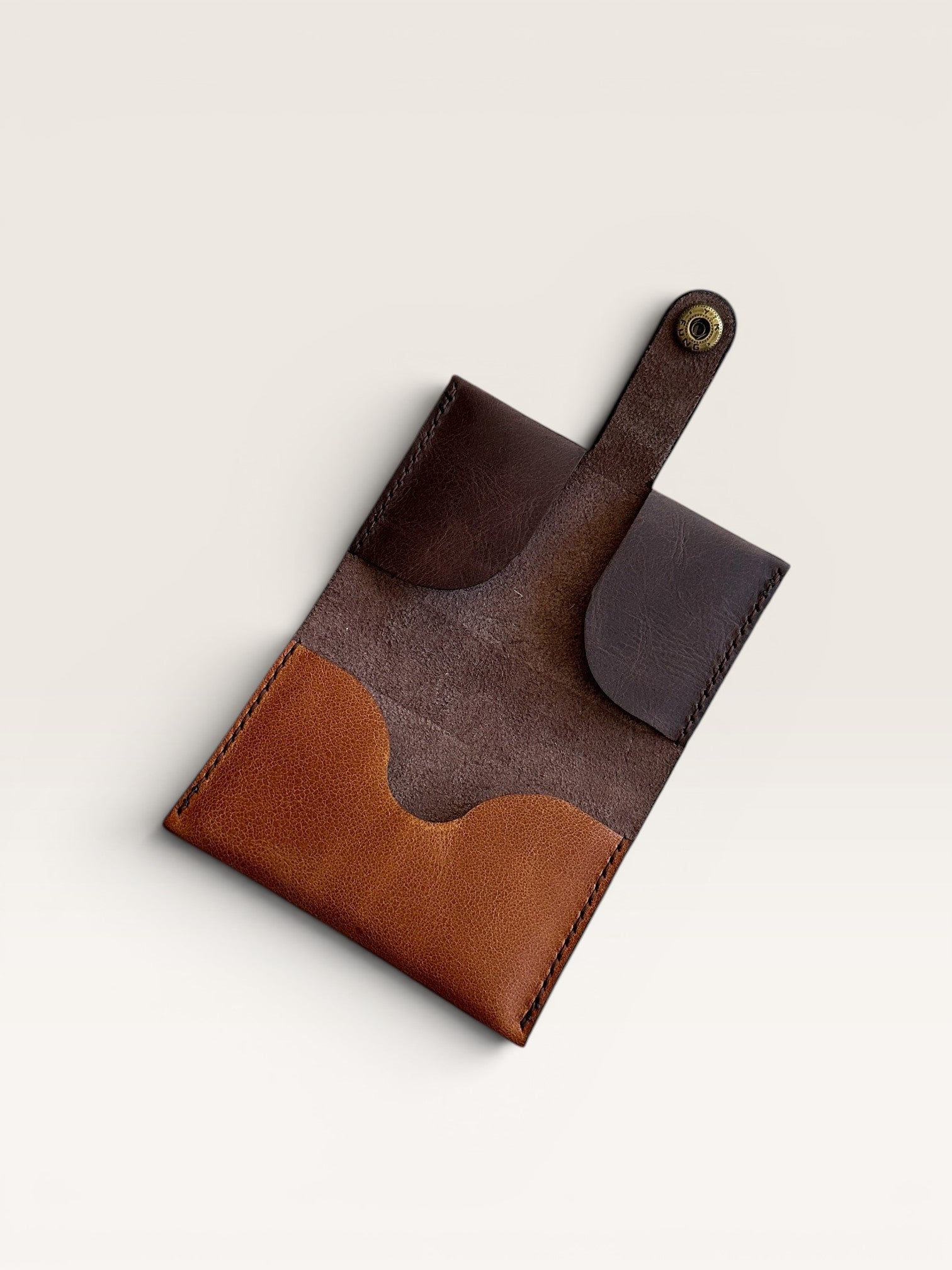 Safir Leather minimalist card holder made of genuine leather in brown and tan with a snap closure.