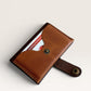Safir Leather minimalist tan genuine leather card holder with snap closure and dark brown trim.