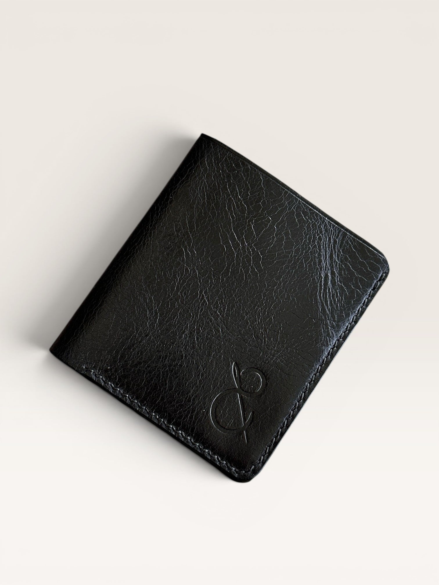 Safir Leather siyah hakiki deri, elde dikilmiş, minimal tasarımlı, 10x8.5 cm boyutlarında, 6-12 kart kapasiteli, unisex cüzdan.