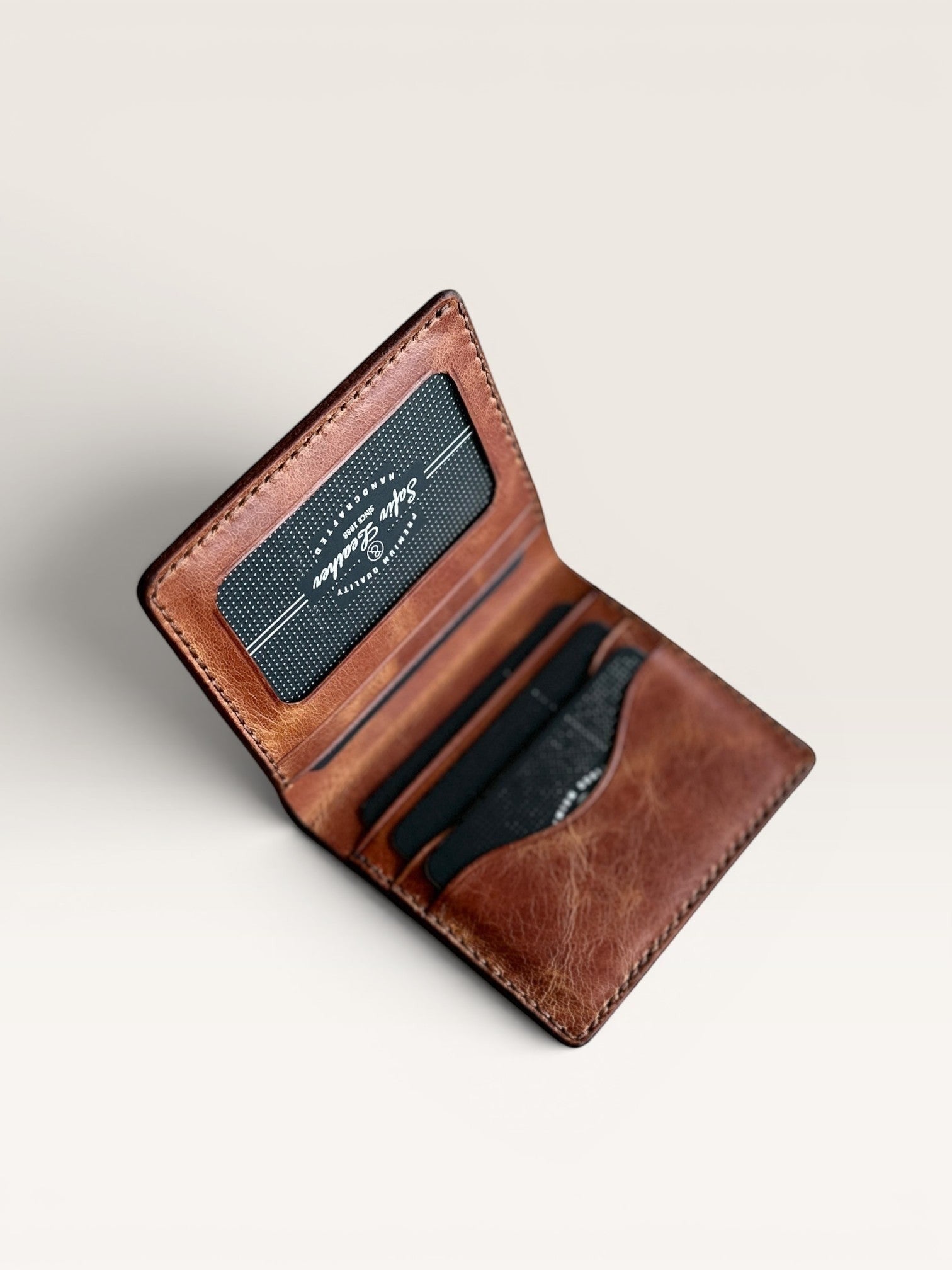 Safir Leather el yapımı taba rengi İtalyan deri cüzdan, kart bölmeli ve şık tasarımlı.