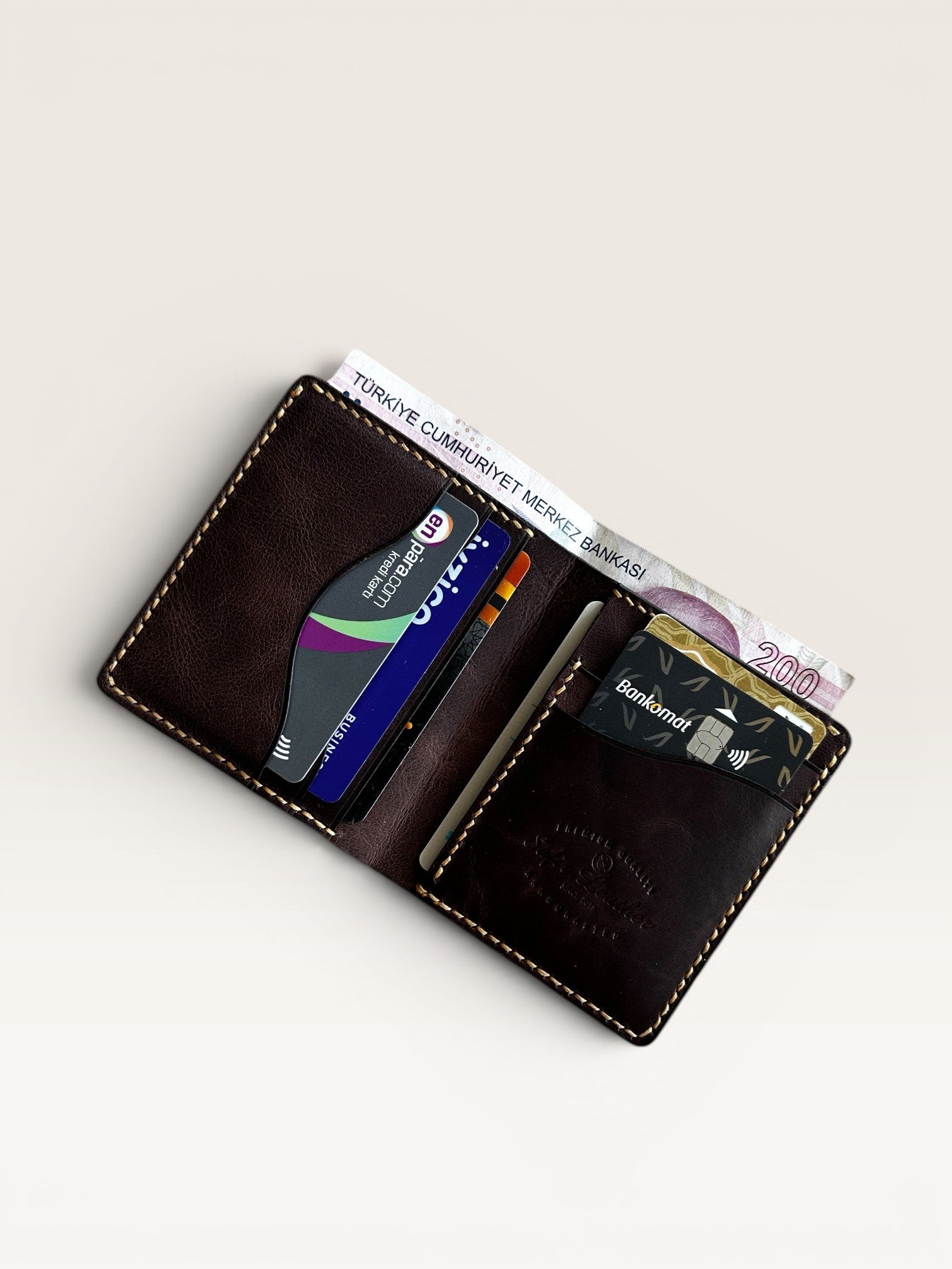 Safir Leather el yapımı taba rengi İtalyan deri cüzdan, kartlar ve nakit para için pratik bölmeler sunar.